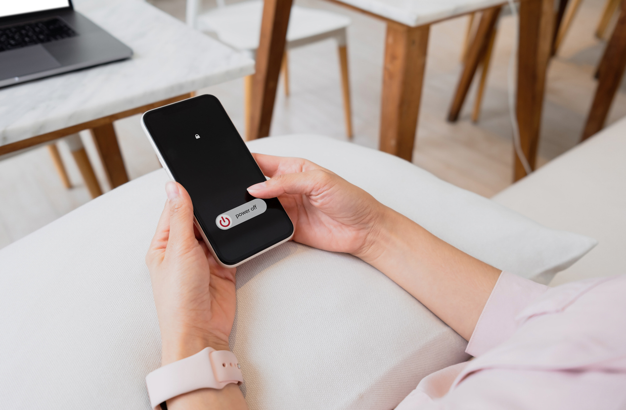 Woman hand using is sliding to turn off the mobile phone to reduce power consumption. Technology and environment concept