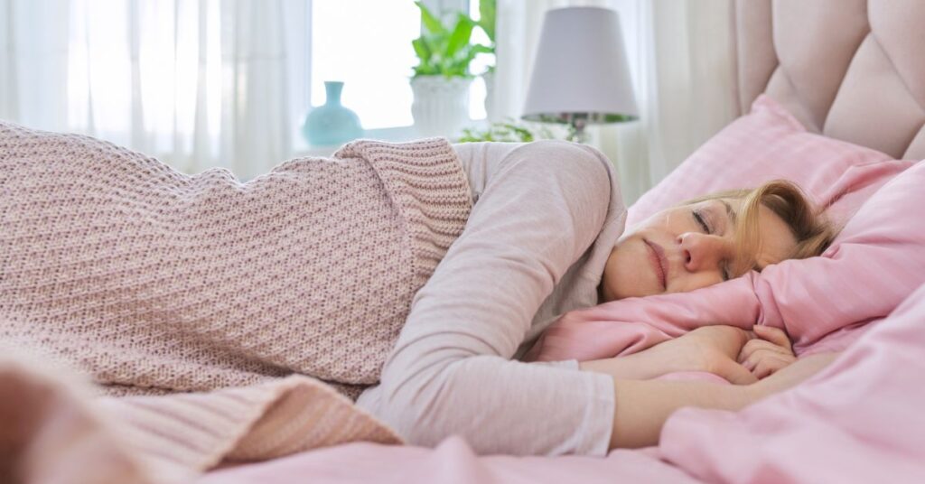 A woman in a room with morning sunshine sleeping peacefully.